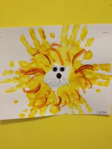 a child's drawing of a lion made out of yellow and orange paint on white paper