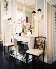 a living room filled with furniture and a fire place in front of a wall mounted mirror