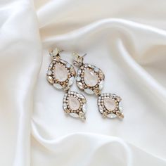 Feel like a modern-day royalty with our luxurious GIANNA statement bridal earrings. Handcrafted with dazzling Austrian crystals, the earrings make a bold and sophisticated statement. Perfect for all special occasions! PLEASE ALLOW APPROX 10 BUSINESS DAYS FOR COMPLETION BEFORE SHIPPING- Handcrafted with Austrian crystals - Each stone is set by hand in my studio- Golden shadow, ivory cream, white opal and clear stones- Antique gold finish- Earrings measure 3.25 inches x 1.125 inch- Handcrafted in the US.- Nickel free and hypoallergenicThis is an original design by © Treasures by Agnes FOR MATCHING PIECES SIMPLY TYPE "GIANNA" IN THE SEARCH BAR Glamorous Crystal Earrings For Weddings, Crystal Embellished Drop Bridal Earrings, Opulent Silver Earrings For Wedding, Glamorous Crystal Earrings With Sparkling Stones, Luxury Rhinestone Wedding Earrings, Glamorous Jeweled Wedding Earrings, Luxury Rhinestone Earrings For Wedding, Silver Opulent Earrings For Evening, Opulent Silver Earrings For Evening