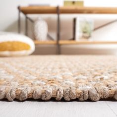 a close up view of a rug on the floor in a room with white walls