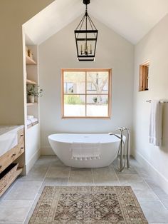 a bathroom with a bathtub and rug on the floor