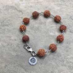 "Lovely Rudraksha Seed Beads wrapped in oxidized sterling silver with a Hilltribe fine silver OM charm. This beaut is 7 1/4\" and closes securely with a sterling silver lobster clasp. Rudraksha is worn at all times or kept close to the skin, it is a sacred seed that emits a potent protective energy, enabling the wearer to achieve their greater potential." Spiritual Silver Beaded Bracelets, Spiritual Bracelet With Oxidized Finish As Gift, Sterling Silver Spiritual Bracelet For Meditation, Spiritual Sterling Silver Beaded Bracelets, Nickel Free Spiritual Beaded Bracelets For Healing, Spiritual Sterling Silver Bracelets, Nickel-free Spiritual Beaded Bracelets For Healing, Spiritual Sterling Silver Beaded Bracelets With Round Beads, Spiritual Beaded Bracelets With Sterling Silver Clasp