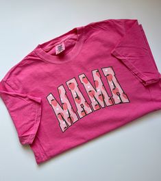 "This Comfort Colors® t-shirt features a charming strawberry print with the word \"mama\" in bold letters. The shirt is made from soft and durable cotton material, ensuring maximum comfort and longevity. It comes in a range of sizes to fit different body types and is perfect for casual wear or as a thoughtful gift for a mother figure in your life. The vibrant colors of the print are sure to make a statement and add a touch of sweetness to any outfit. All items are made to order in the order in w Shirts For Moms, Fruit Shirt, Bold Letters, Strawberry Print, Mama Shirts, Mama Shirt, Graphic Tees Women, Branded T Shirts, Strawberries