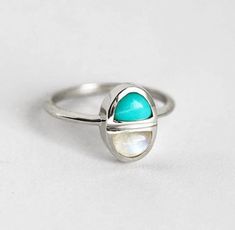 Experience the elegance of our Moonstone Mom Ring with turquoise accents, celebrating maternal grace and eternal love. Meticulously crafted and adorned with shimmering gems, it symbolizes the nurturing spirit of motherhood, a cherished token of affection and sentiment in exquisite design. Turquoise Multi-stone Promise Ring Jewelry, Turquoise Spiritual Jewelry For Anniversary, Spiritual Turquoise Jewelry For Anniversary, Turquoise Multi-stone Ring For Gift, Turquoise Birthstone Ring With Accent Stones, Turquoise Sterling Silver Jewelry For Promise, Turquoise Birthstone Ring With Accent Stones As Gift, Turquoise Birthstone Ring With Accent Stones For Gifting, Spiritual Turquoise Gemstone Ring For Promise