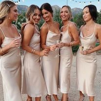 a group of women standing next to each other wearing dresses and high heeled sandals