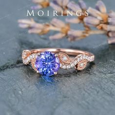 a tan and blue ring with white diamonds on the side, sitting next to lavender flowers