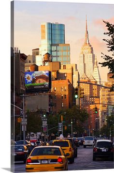 a city street filled with lots of traffic next to tall buildings in the evening sun