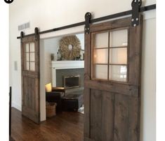 an open door leading to a living room with a fireplace in the corner and wood floors