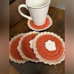 three crocheted coasters and a cup on a table