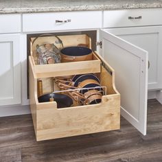 an open drawer in the middle of a kitchen with dishes and utensils inside