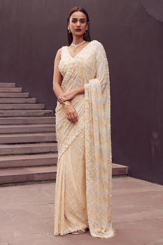 Beige saree with all over geometric embroidery using sequins and beads. Paired with a blouse with all over floral embellishments using tonal sequin work. - Aza Fashions Festive Pre-draped Sequined Dola Silk Saree, Sequin Pre-draped Chinon Saree, Diwali Sequined Chinon Blouse, Traditional Georgette Pre-draped Saree With Sequins, Elegant Chanderi Traditional Wear With Sequins, Sequined Chinon Fabric For Reception, Sequin Embellished Chinon Fabric For Reception, Unstitched Sequined Blouse Piece For Designer Wear, Elegant Dola Silk Choli With Sequins