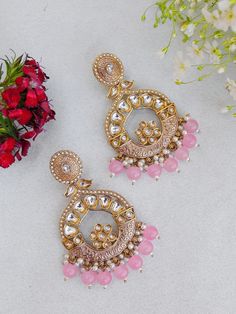 Unleash your inner diva with our mesmerizing Indian Kundan Earrings. Designed to make a bold statement, these earrings exude captivating splendor, blending traditional Indian aesthetics with contemporary allure. Crafted with meticulous attention to detail, these earrings showcase the artistry of Kundan work. The vibrant Kundan stones take center stage, radiating a luminous charm that catches every eye. The intricate setting in gleaming golden tones adds an element of opulence and elevates their Pink Round Danglers For Wedding, Kundan Earrings With Zari Work, Round Kundan Earrings With Zari Work, Fusion Kundan Jhumkas With Meenakari, Fusion Style Kundan Jhumkas With Meenakari, Fusion Style Meenakari Danglers For Celebration, Fusion Meenakari Danglers For Celebration, Heavy Round Chandbalis For Festive Occasions, Fusion Style Jewelry With Meenakari For Eid