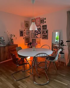 a white table and chairs in a room with pictures on the wall