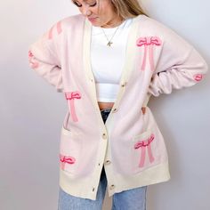 Stay Cozy And Chic With Our Oversized Bow Cardigan. Crafted From Soft, Luxurious Knit Fabric, This Cardigan Features An Effortlessly Elegant Bow Design Throughout , Adding A Touch Of Femininity To Your Look. With Its Relaxed Fit And Versatile Style, It's Perfect For Layering Over Your Favorite Tops For A Polished Yet Comfortable Ensemble. Whether You're Lounging At Home Or Stepping Out For A Casual Outing, This Cardigan Is Sure To Keep You Stylishly Snug All Day Long. Features - Front Buttons - Pink V-neck Cardigan For Loungewear, Feminine Sweater For Winter Day Out, Feminine Winter Sweater For Day Out, Feminine Sweater For Day Out In Winter, Feminine Long Sleeve Sweater For Day Out, Oversized Trendy Pink Cardigan, Feminine Winter Cardigan For Loungewear, Chic Pink V-neck Cardigan, Feminine Fall Loungewear Cardigan