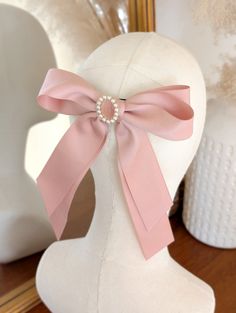 An enchanting Pale Pink Matt Satin hair bow with an antique style pearl and pink cameo centre The perfect hair bow to elevate any look.  Also available in light blue and cream. *DETAILS*  * The bow is attached to a silver french Barrett hair clip * measurements - 17cm across 22cm down * your bow will arrive in a gift box with luxury ribbon.  *DELIVERY DEATAILS* All UK orders are sent via the Royal Mail 1st Class Signed for service. All international orders are sent via a Tracked and Signed service where possible. SHOP MORE STYLES: Honeyandember.etsy.com/ FIND ME ON: www.instagram.com/honey_and_ember Pale Pink Hair, Pink Hair Bow, Bow Barrette, Pink Hair Bows, Style Cottage, Cottagecore Style, Rose Pale, Ribbon Hair Bows, Claw Clips