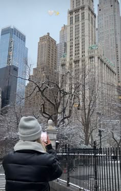 a person sitting on a bench looking at the view of skyscrapers in new york city