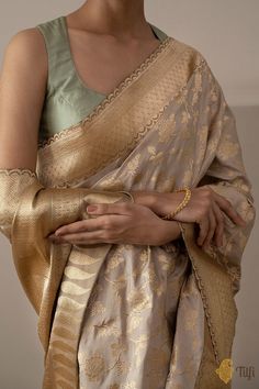 "An exquisite saree, elaborately\u00a0handcrafted with love. This drape\u00a0has\u00a0a subtle hue and charming gold zari floral jangla woven in kadwa style\u00a0on a bed of pure katan silk. Elegance redefined!\n\u00a0\n\n\nColor\u00a0- An enchanting shade of\u00a0Beige Brown\n\nTechnique\u00a0-\u00a0An enduring Kadwa weave. The elaborate and laborious Kadwa (Kadhua) technique involves hand-weaving each motif separately. It takes longer on the handloom, but makes a more robust pattern, which sta Gold Silk Saree, Katan Saree, Banaras Sarees, Floral Saree, Traditional Blouse Designs, Indian Saree Blouses Designs, Wedding Silk Saree, Indian Bridal Fashion, Ethnic Outfits