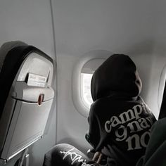 a person sitting on an airplane seat looking out the window