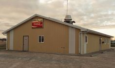 a small building with a coca cola sign on the roof and a radio tower in the background