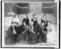 a group of women sitting next to each other on steps in front of a building