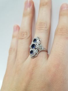 Once in a Blue Moon vintage finds. Antique Style Sapphire CZ Ring // Solid 925 Sterling Silver. Lab Created Gemstones. The deep blue sapphire stones are set in a gothic filigree setting featuring six tiny CZ's. Size: 7 US Central Sapphire: 0.46 ct (5 mm) Top and Bottom Sapphires, each: 0.28 ct (4.25 mm) Weight: 3.55 g Band width: 1.6 mm Free Shipping, Upgrade to Gift Wrap for a leatherite ring box! Three Stone Sapphire Round Ring Fine Jewelry, Blue Sapphire Three Stone Ring With Diamonds, Fine Jewelry Sapphire Three Stone, Fine Jewelry Tanzanite Three Stone, Blue Topaz Three Stone Blue Jewelry, Fine Jewelry Blue Three Stone Jewelry, Blue Sapphire Ring With Diamond, Fine Jewelry Three-stone Sapphire Ring, Tanzanite Three Stone Wedding Jewelry