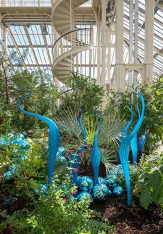 blue sculptures are in the middle of a garden