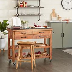 a kitchen island with two stools in front of it and shelves on the wall