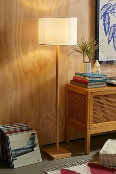 a lamp that is sitting on top of a wooden table next to a book shelf