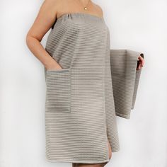 a woman in a gray dress is holding a towel