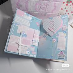 an open pink and blue planner book with hello kitty stickers on the pages, sitting on a table