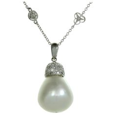 This classic Diamond By The Yard pendant necklace is crafted in 18k white gold and set with 16.0mm x 18.0mm South Sea Baroque Pearl with silver overtones, accented with brilliant-cut round diamonds of an estimated 1.65 carats. Made in United States circa 1990s. Measurements: 1.22" (31mm) pendant, 18" (45.7cm) chain. Diamond By The Yard, White Gold Pendant Necklace, White Gold Pendant, South Seas, Gold Pendant Necklace, Baroque Pearls, Pearl White, Gold Pendant, Round Diamonds