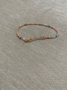 This bracelet is handmade. It is made with small dainty beads Minimalist Beaded Stretch Bracelet For Gift, Dainty Handmade Round Bead Bracelets, Delicate Adjustable Beaded Chain Bracelet, Adjustable Delicate Bracelets With Colorful Beads, Delicate Adjustable Bracelets With Colorful Beads, Delicate Beaded Bracelets With Round Beads, Handmade Minimalist Crystal Bracelet With Round Beads, Dainty Multicolor Beaded Chain Bracelets, Delicate Beaded Pearl Bracelet