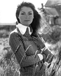 black and white photograph of a woman standing in tall grass with her hands on her hips