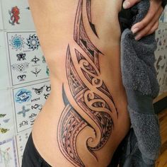 a woman's lower back tattoo with an intricate design on the ribs and side