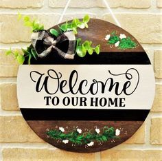 a welcome sign hanging on the side of a brick wall