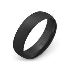 a black wedding band with a cross on the center and an engraving in the middle