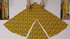 someone is cutting out the pattern for a dress with yellow and black flowers on it