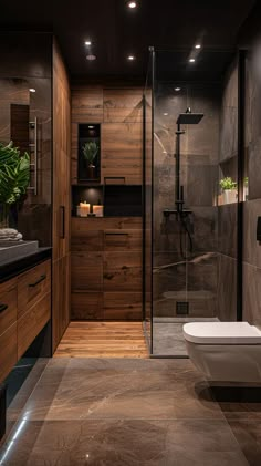 a modern bathroom with dark wood and marble walls, flooring, and a glass enclosed shower stall