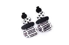 These black and white earrings are a super fun accessory to top off an outfit. Each earring features solid black acrylic charms paired with black and white triangle print and chevron charms. They are the perfect mix of patterns that is far from boring! The earrings are finished off with stainless steel ear posts. MATERIALS Acrylic Stainless Ear Posts LENGTH 2 1/4" CARE Direct contact with perfumes and moisture should be avoided to minimize damage or discoloration. Please remove before showering, Bold Black Drop Earrings, Trendy Black Geometric Earrings, Trendy Black Geometric Jewelry, Black And White Earrings, Triangle Print, Acrylic Charms, Black Acrylics, Black Acrylic, White Earrings