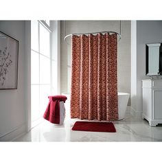 a bathroom with a red shower curtain next to a white bathtub and sink in front of a window