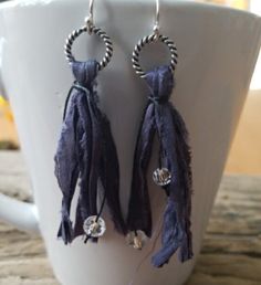 "Be on trend with our uniquely yours beaded tassel earrings! We've started with different colors of vintage ribbon, and repurposed it into our own handmade tassels--your choice of navy blue, emerald green, or khaki (one with a silver ring and the other with a copper ring). The tassels are made hanging from a nickel free ring (see your choices) and then tied with small crystal czech glass beads to give you a little bling. The drop on these earrings varies between 2.5\" and 3\", so they are not to Elegant Blue Tassel Earrings For Festival, Trendy Summer Jewelry With Tassels, Trendy Dangle Tassel Earrings For Festivals, Trendy Tassel Dangle Earrings For Festival, Trendy Fringe Jewelry Gift, Trendy Fringe Jewelry As Gift, Trendy Fringe Jewelry For Gifts, Trendy Fringed Jewelry As Gift, Trendy Festival Jewelry With Fringe