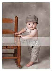 a baby standing next to a wooden chair