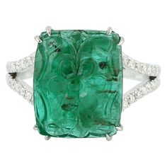 This ring has been meticulously crafted from 18-karat gold. It is hand set in 8.16 carats carved emerald & .24 carats of diamonds. The ring is a size 7 and may be resized to larger or smaller upon request. FOLLOW MEGHNA JEWELS storefront to view the latest collection & exclusive pieces. Meghna Jewels is proudly rated as a Top Seller on 1stDibs with 5 star customer reviews. All items manufactured by us are handmade and can be customized or redesigned. Composition Size-US-7 Total Weight-5.525 Gold Oval Emerald Rings With Pave Setting, Octagon Emerald Ring With Diamond Accents, Luxury Emerald Gemstones With Prong Setting, Luxury Emerald Cut Gemstone With 17 Jewels, Exquisite Green Emerald Ring With Pave Setting, Luxury Green Emerald Ring With Single Cut Diamonds, Luxury Emerald Jewelry With Single Cut Diamonds, Exquisite Green Jewelry With Pave Setting, Green Platinum Jewelry With Pave Setting