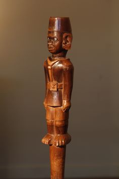 a wooden carved figure standing on top of a table