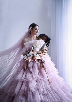 a woman in a pink dress holding a bouquet