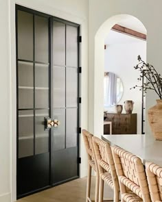 a dining room table and chairs in front of a black door