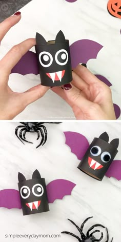 a hand holding up a paper bat with eyes and fangs on it, next to some halloween decorations