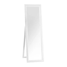 a tall white mirror sitting on top of a table