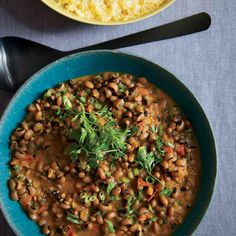 a blue bowl filled with beans and vegetables