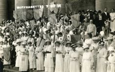 a large group of people standing next to each other in front of a tall building